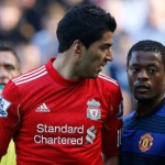 Liverpool's Suarez looking at Manchester United's Evraield in Liverpool