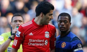 Liverpool's Suarez looking at Manchester United's Evraield in Liverpool