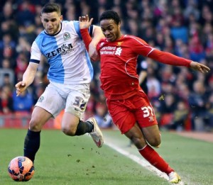 Liverpool's Raheem Sterling is held off by Craig Conway of Blackburn